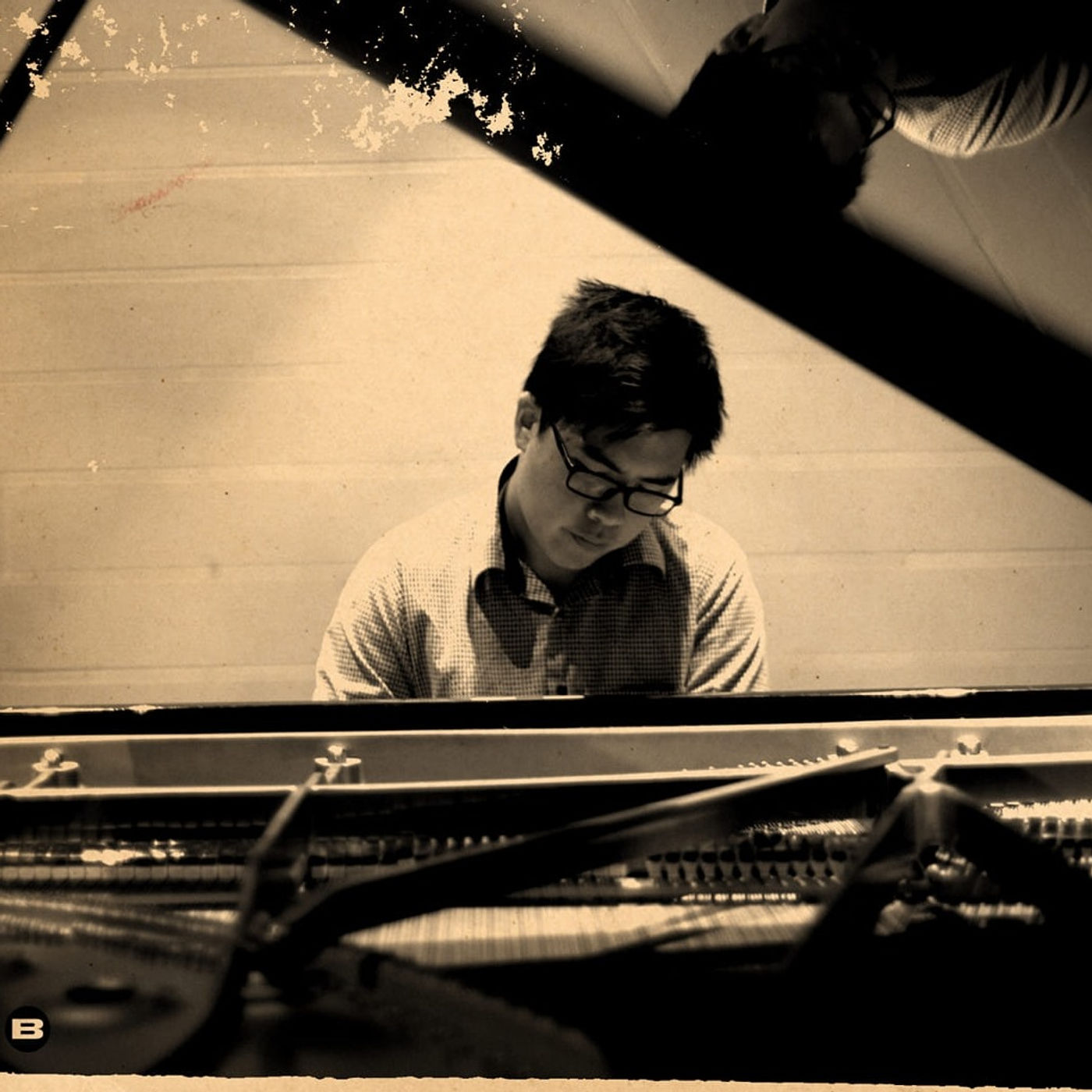 Close-up of Tanakrit's hands on the keys of a concert grand piano