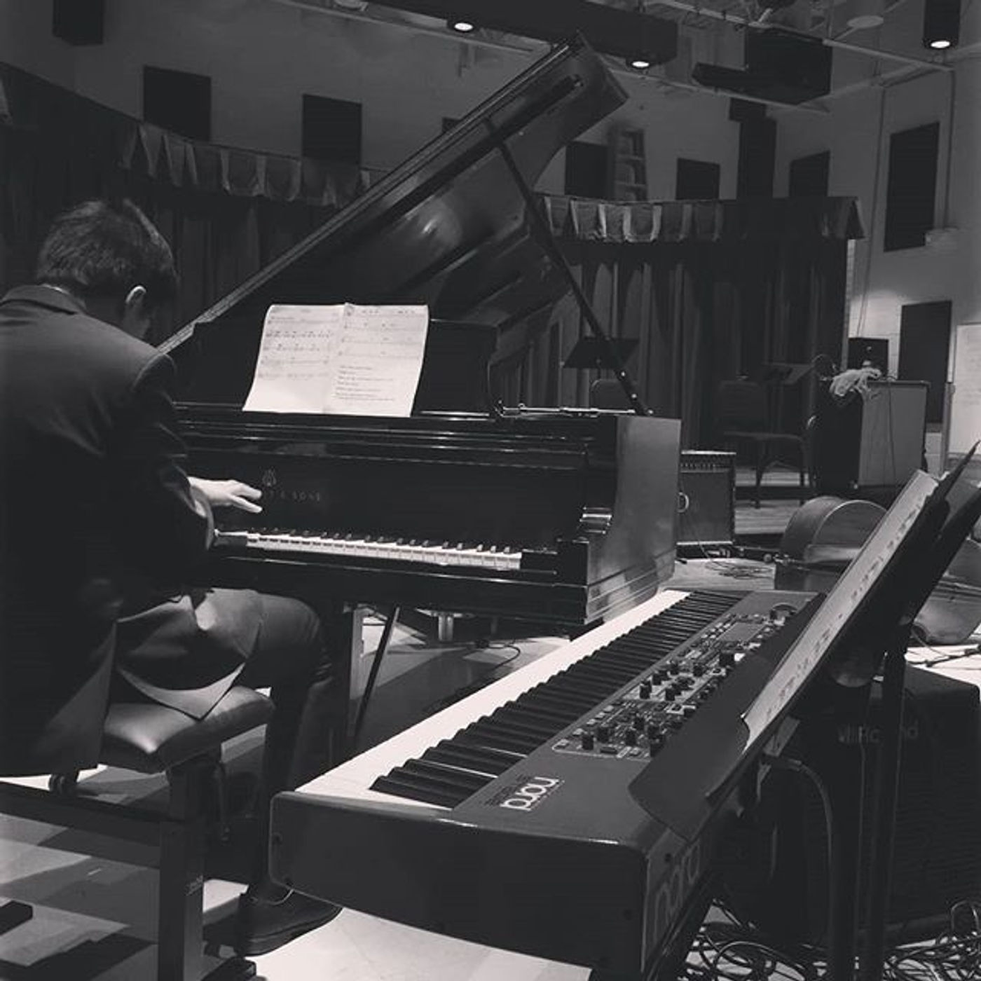 Tanakrit at the grand piano on stage during an evening performance